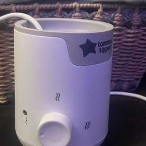 A grey and white Tommee Tippee bottle warmer